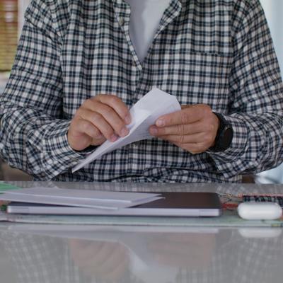 A man opening an envelope at home.