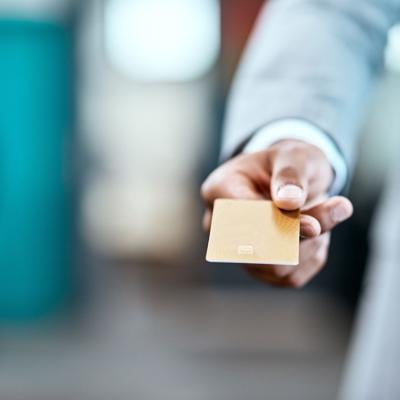 A businessman handing a credit card for payment.