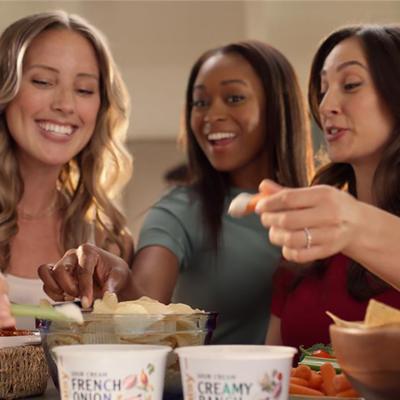 A group of women eating chips with french onion dip.