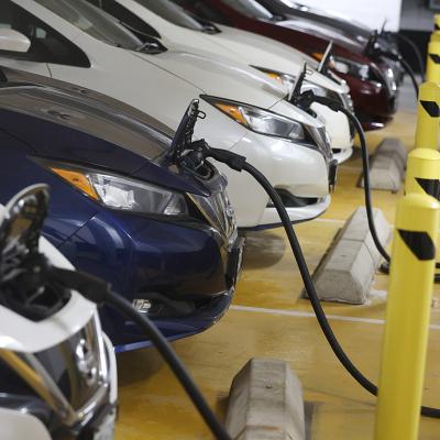 A row of parked electric cars being charged.