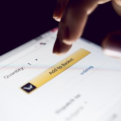 Person about to tap 'Add to basket' button on a shopping app.