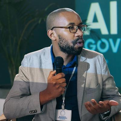 A black businessman giving a presentation on AI governance in a conference.