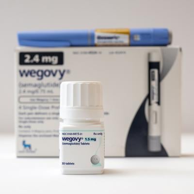 A bottle of Wegovy tablets its box and an Ozempic pen in the background.