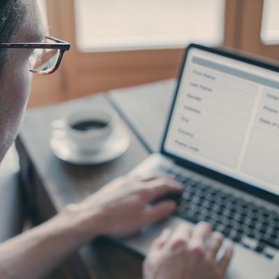 Man using laptop at home to fill out a form online.