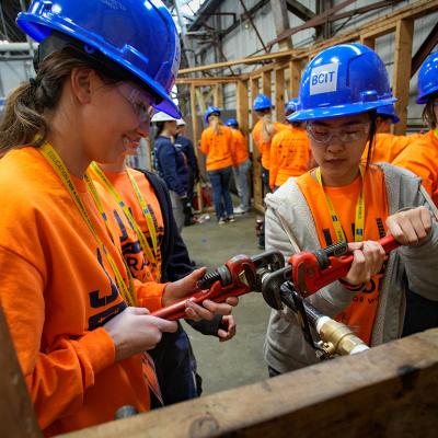 A group of female high school students participating in a skills trade workshop.