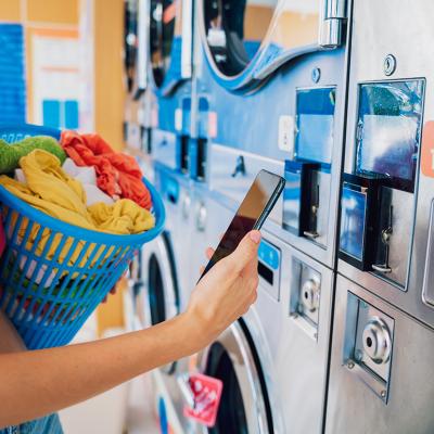 A young woman paying for a laundromat using a mobile app.