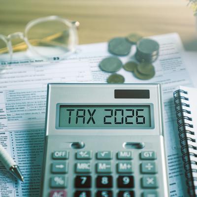 Calculator showing 'tax 2026' over tax documents.