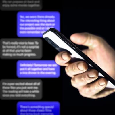 Person using a smartphone against a background of chat bubbles.