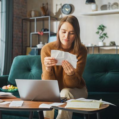 Woman at home looking at receipts.