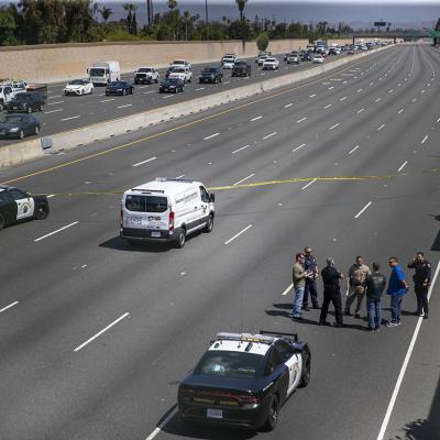 Crime scene investigators gather on the side of California Highway where a 6-year-old boy was fatally shot during a road rage incident on 55 Freeway in Orange.