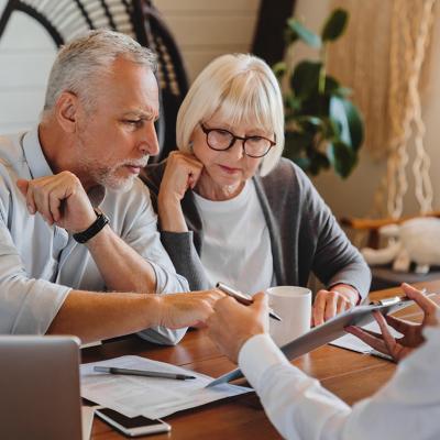 A senior couple consulting with a real estate professional.