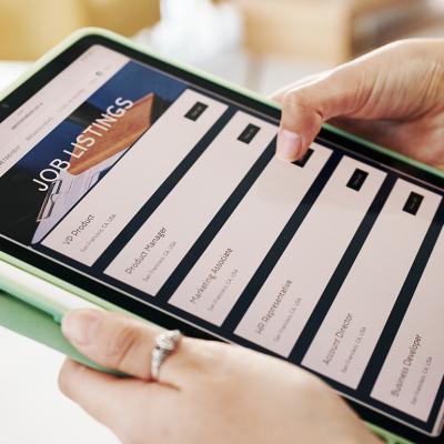 Person browsing job listings online using a tablet.