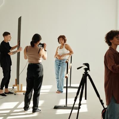 A creative team photographing a fashion model in a studio.