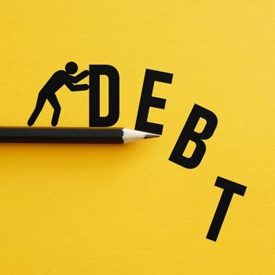 Man pushing away figures of the letters "D, E, B, T" as a concept of relieving debt.