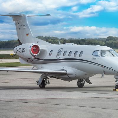 A Phenom 300 aircraft at an airport getting ready for a flight.