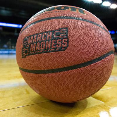 A game ball labeled with 'March Madness' on a basketball court.