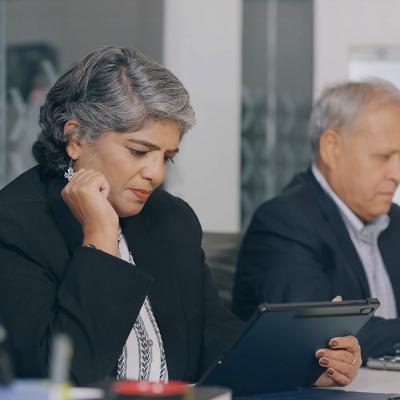 Two senior businesspeople reviewing reports at an office.