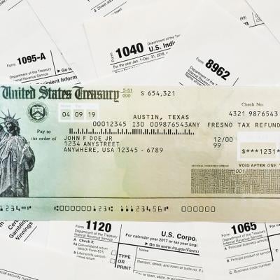 A US Treasury refund check on top of tax forms.