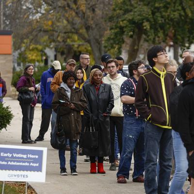 People wait in line to vote during early voting for the 2024 US general election at a polling station at Ottawa Hills High School in Grand Rapids, Michigan.