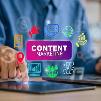 A content creator using a laptop and tablet with content marketing concept icons.