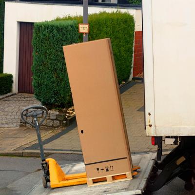A large parcel box being loaded in a shipping truck.