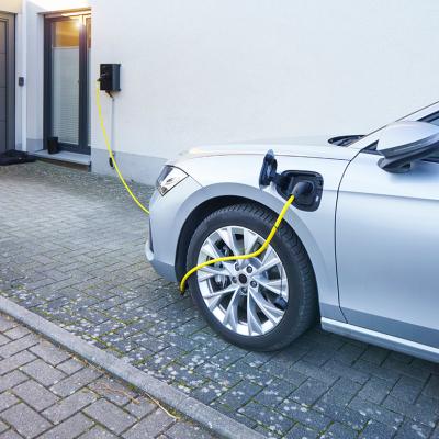 A car connected to an EV charger at home installed in the driveway.