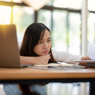 A tired employee looking though a paperwork in the office.