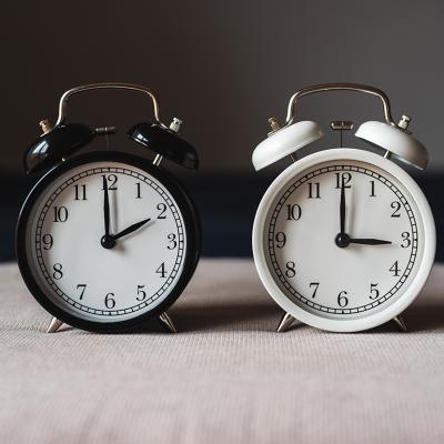 Two retro table clocks representing daylight savings time.