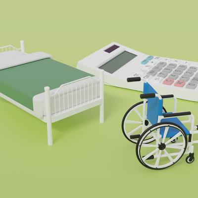 3D graphics of a miniature bed, a wheelchair, and a calculator as a concept of special care costs.