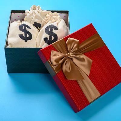A gift box full of bags with dollar symbols.