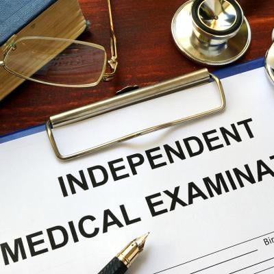 An independent medical examination form on a clipboard.