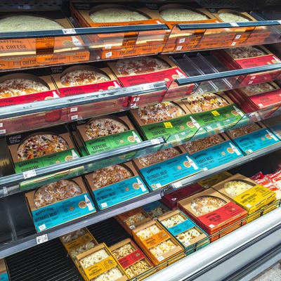 Frozen pizza section at a grocery store.