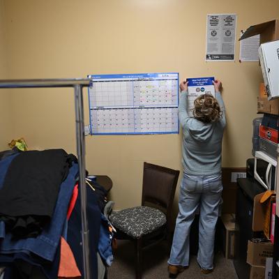 Denver Labor and Auditor's Office staff hangs a poster about wage changes.