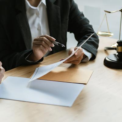 A legal counsel presenting a contract to a client in a law office.