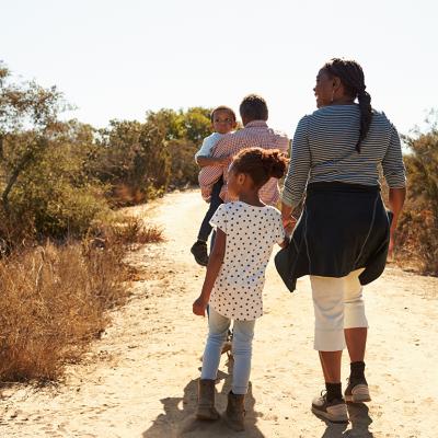 Grandparents walking outdoors with their grandchildren.