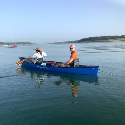 Two people on a boat on a lake.
