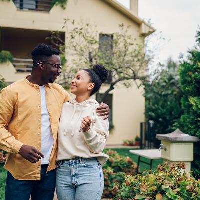 A couple standing outside their new home after moving in. 