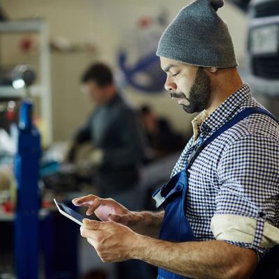 A mechanic using a tablet to process an order.