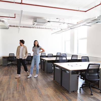 Colleagues looking around an empty modern office for startup plans.