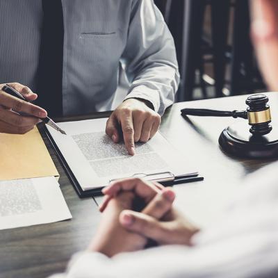 A lawyer consulting with his client and reviewing documents.