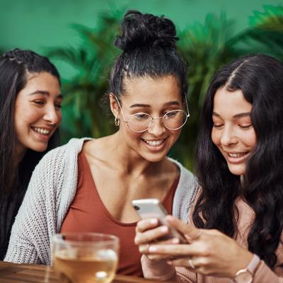 Friends checking social media in a cafe. 