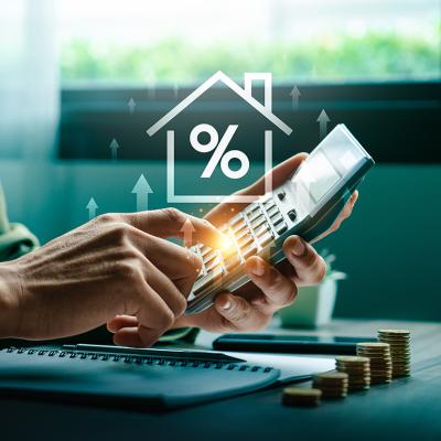 Person using a calculator illustrated with increasing mortgage rate concep graphics.