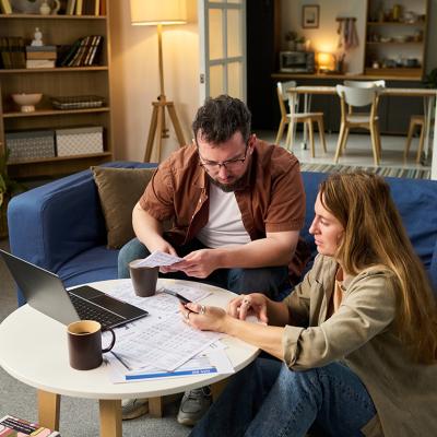 Two people reviewing expenses and financial documents for tax filing.