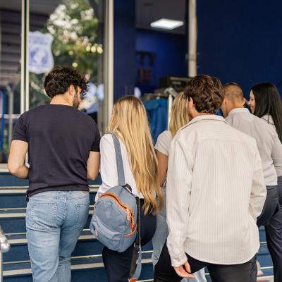 Five college students walking upstairs for a class.
