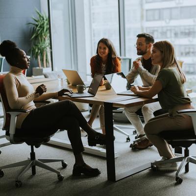 An employee sharing ideas to teammates in a workplace meeting.