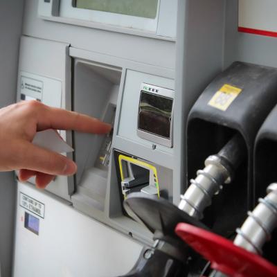 Person entering numbers on a fuel pump station keypad.