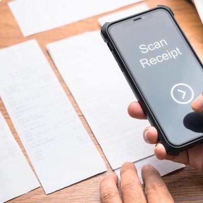 A person scanning paper receipts from a smartphone.