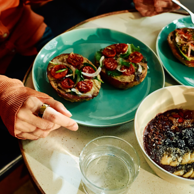 Plates of special bagels and a healthy oat meal served on a table.