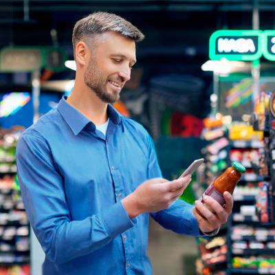 Man at a supermarket scanning the QR code of a tomato sauce item.