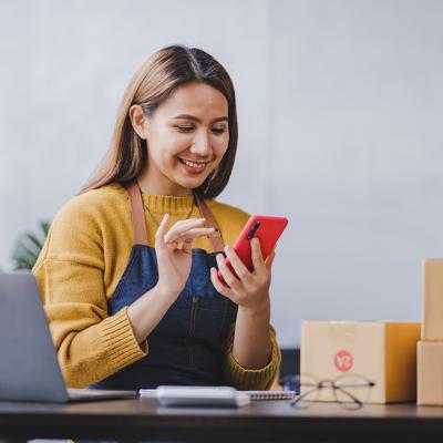 An entrepreneur checking and packing orders from her online marketplace.